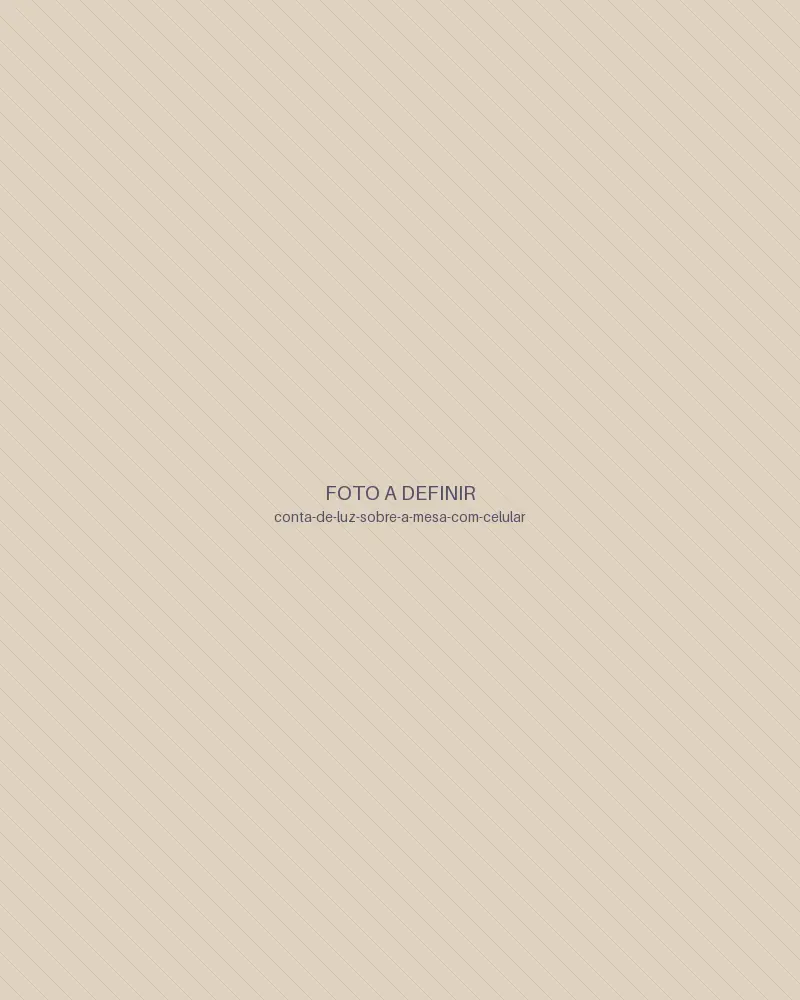 Mãos com a conta de luz sobre a mesa e o celular ao lado (imagem provisória)